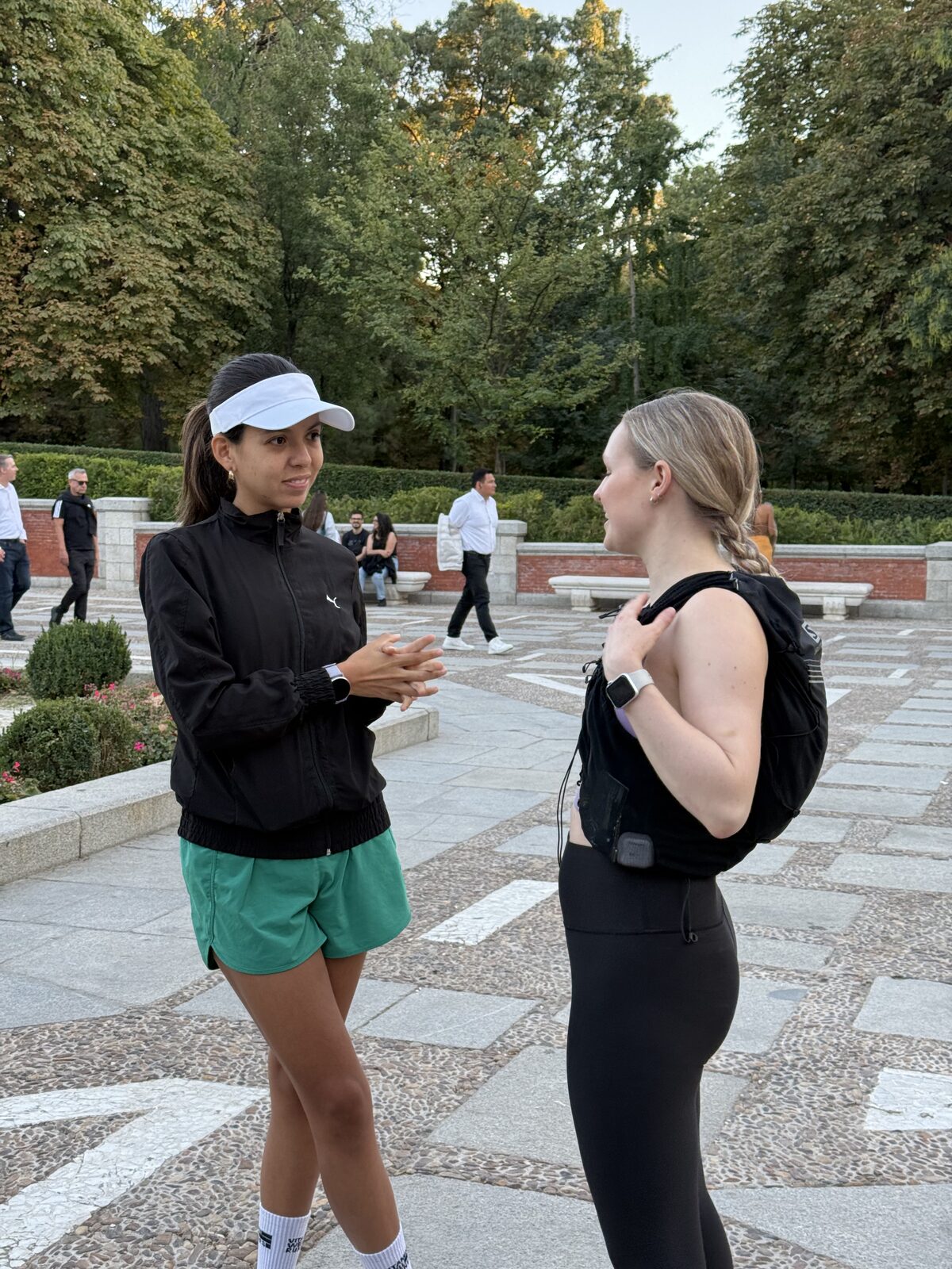 Two members laughing together in a Madrid square after a group run